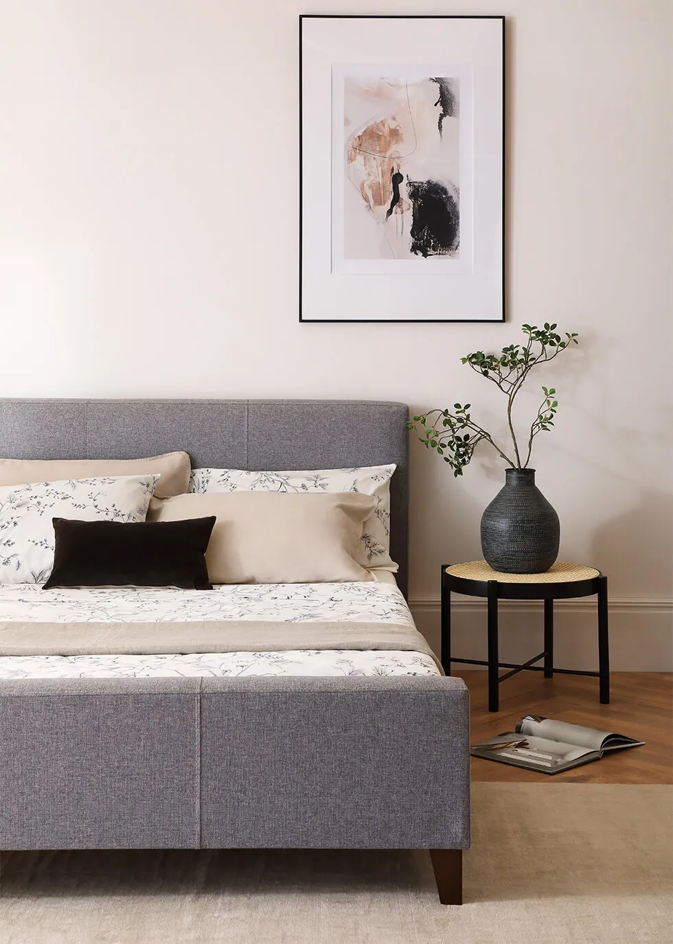 LoveShackFancy Shop 25 LoveShackFancy Shop -LoveShackFancy Shop 6 a minimalist bedroom with a fabric grey bed black side table and abstract wall art